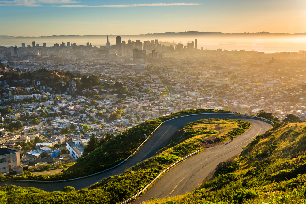 Curvy road and view of downtown at sunrise from Twin Peaks, in San Francisco, California.